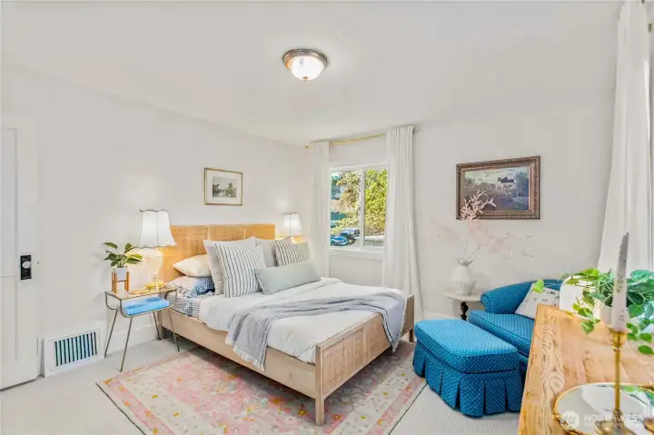 Bright main floor bedroom with neutral tones, dual-pane windows, and versatile use as a guest room, nursery, or retreat.