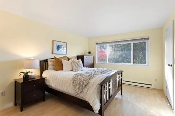 Primary bedroom with large picture window looking west, walk-in closet & en suite bathroom