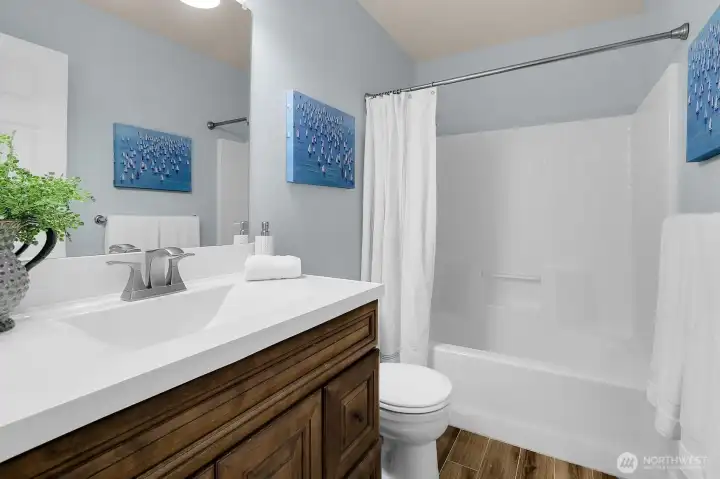 Updated full bath in hall with tile floor, and newer vanity.
