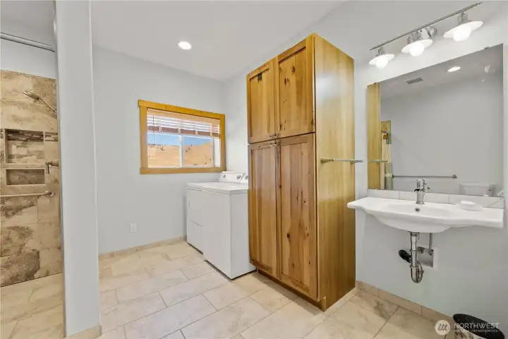 Further down the hall to the rear of the house, the laundry area along with a large walk in shower & wheel chair accessible sink.