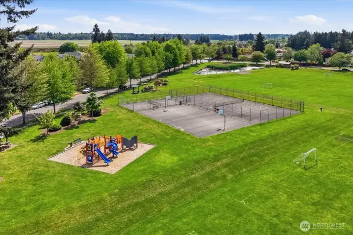 Large park with multiple amenities including basketball courts, tennis and playgrounds.