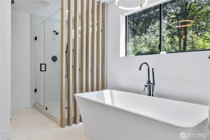 Soaking tub and walk-in showing in the primary suite bathroom