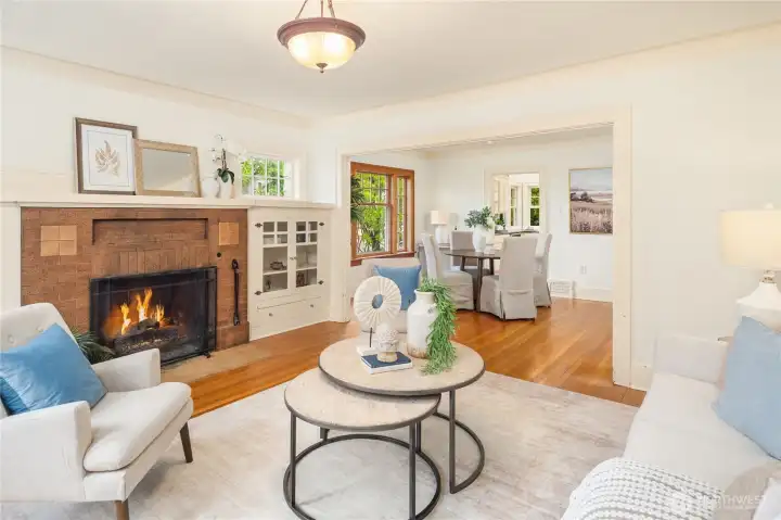 Step into this lovely living room with hardwood floors, brick mantel, and built-in cabinets flanking the wood-burning fireplace.