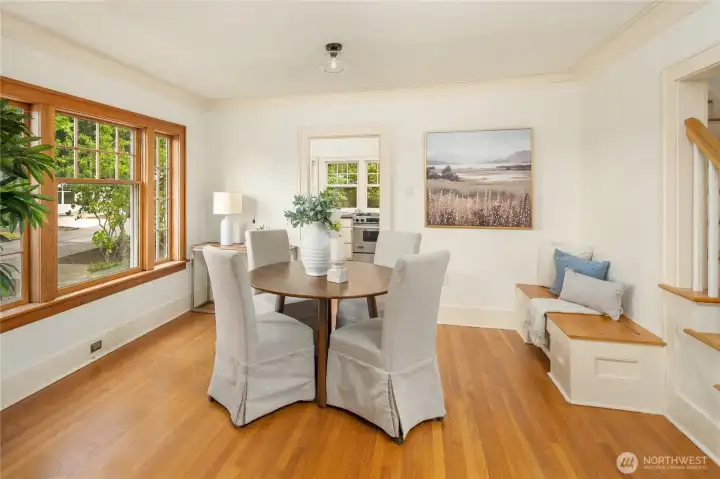 West-facing wood-wrapped window floods the dining room with light. A built-in bench seat offers useful storage inside.