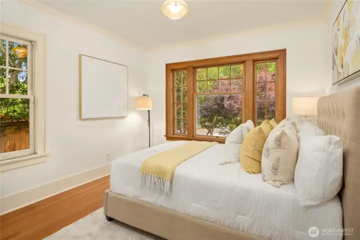 The SW corner bedroom offers hardwood floors and pretty wood-wrapped windows.