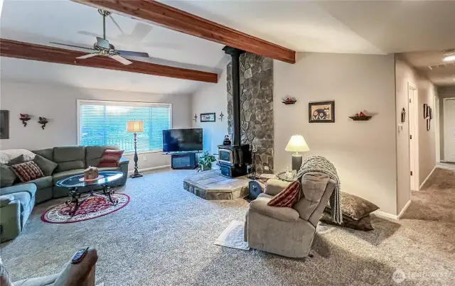 Spacious great room with cozy wood stove and vaulted beam ceilings. Large window with views of the back yard and great for morning light.