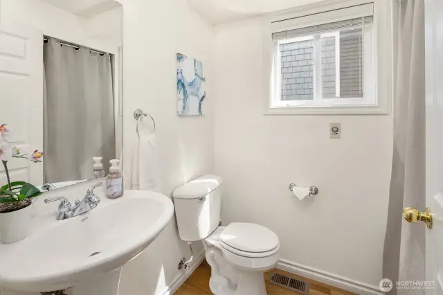 The main-level powder room. The washer and dryer are tucked away behind the curtain.