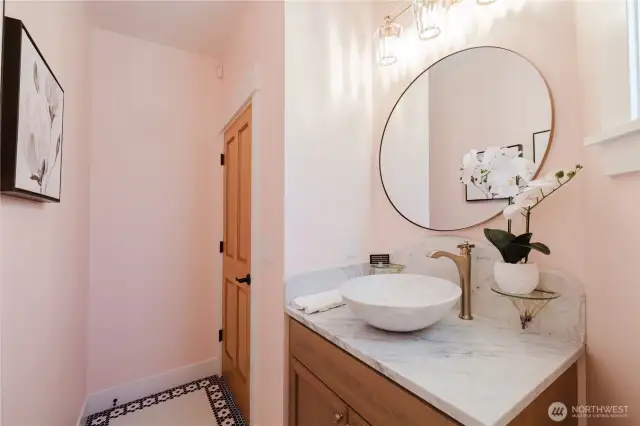 The powder room on the main floor. The beautiful Carrera marble sink matches the antique backsplash which was salvaged from a Baltimore townhouse and attached are stunning Italian Murano Glass shelves.