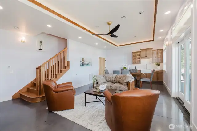Partial view of the recreation/ family room and kitchen on the lower floor. Cherry wood staircase leading up to the main floor.