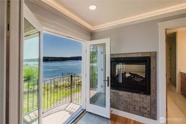 The primary bedroom on the upper level has the best views from the step out balcony. The glass front 2-way fireplace connects the primary bathroom to the bedroom.