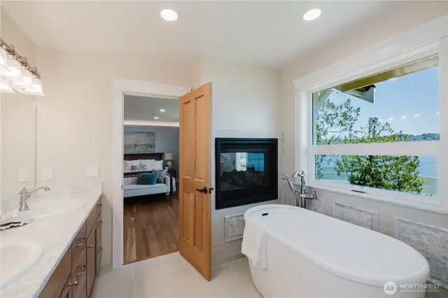 The connected primary bathroom has a soaking tub , double vanity sinks, quartz countertops. Soak in the tub and enjoy the views and warmth from the fireplace.
