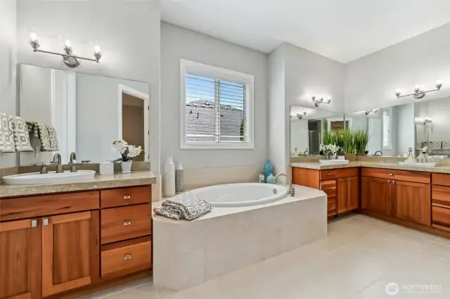 The primary bathroom has split dual vanities and beautiful tile.