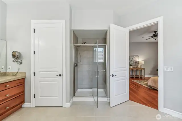 Tiled step-in shower with a swinging glass door for easy access. This photo shows the upgraded door package in the home.