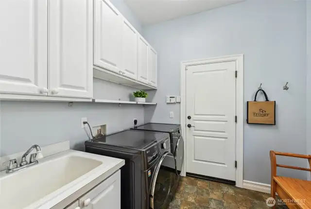 Such a great laundry room with a newer washer & dryer, handy utility sink and nice cabinet storage. The door leads to the garage.