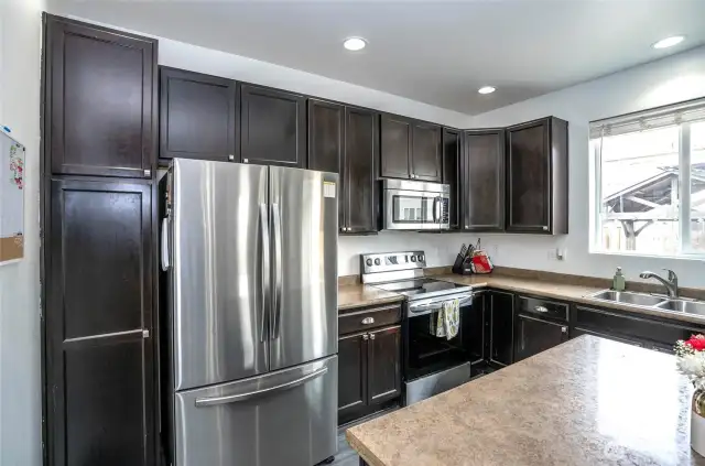 The kitchen features sleek stainless steel appliances and abundant cabinetry for ample storage.