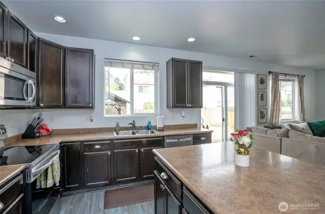 The perfect spot to prepare meals and tidy up without missing a moment—enjoy a view of the backyard and fenced garden area through the window above the sink.