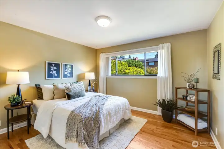 The first bedroom of the home sits in the quiet northeast corner, overlooking the mature landscaping of the front yard.