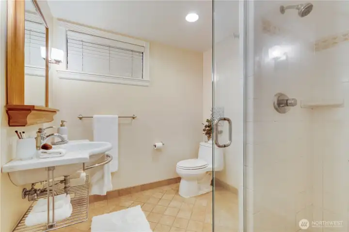 This spacious bathroom serves the lower level. Design the shower to modernize to your taste, as it is ready to be upgraded to new.