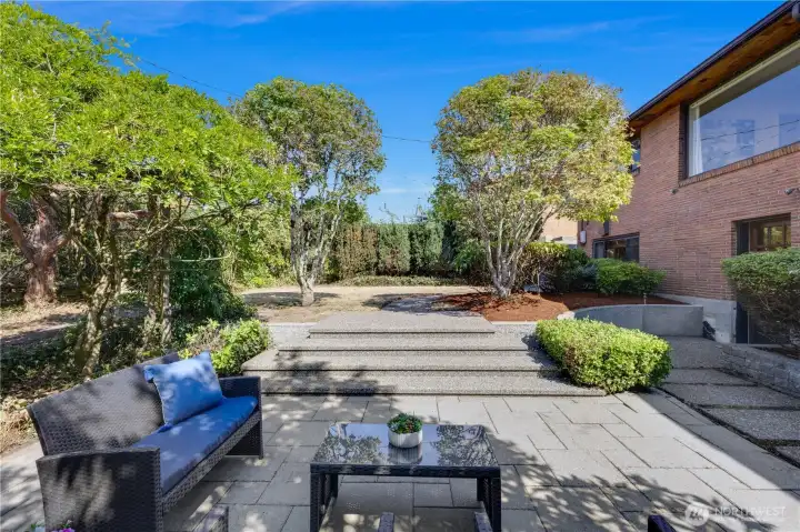 In the backyard, the perimeter of mature trees and shrubs affords year-round beauty and privacy on every side.