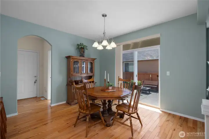 Dining room with hardwood floors and sliding glass door to backyard.