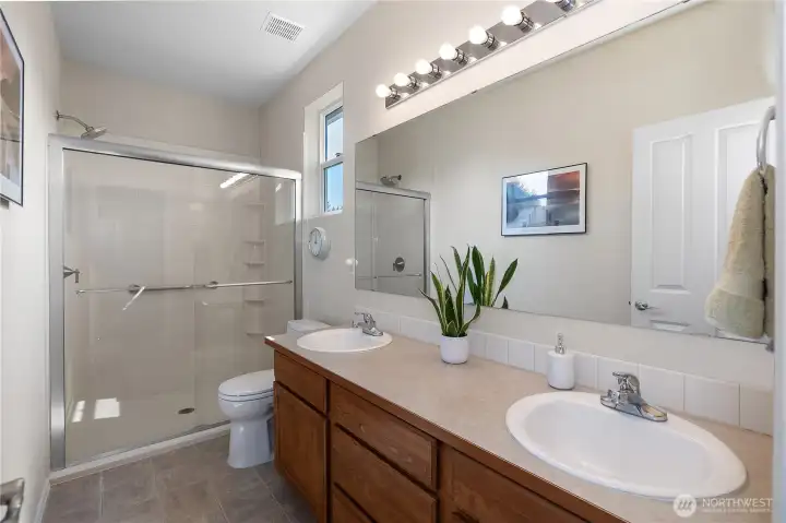 Primary bathroom with newly updated walk-in shower and double vanities.