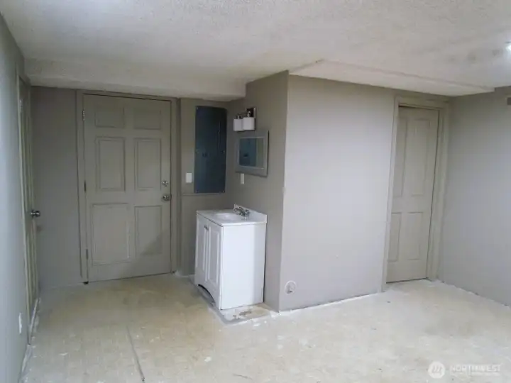 This room has access to the garage off to the left and to the back yard straight ahead.  There is a small bathroom behind the door to the right and a nice vanity and sink directly in front. Put some new floors in and boom its perfect.