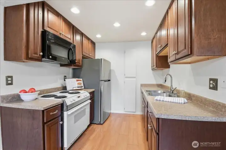 Kitchen has new refrigerator, sink and garbage disposal.