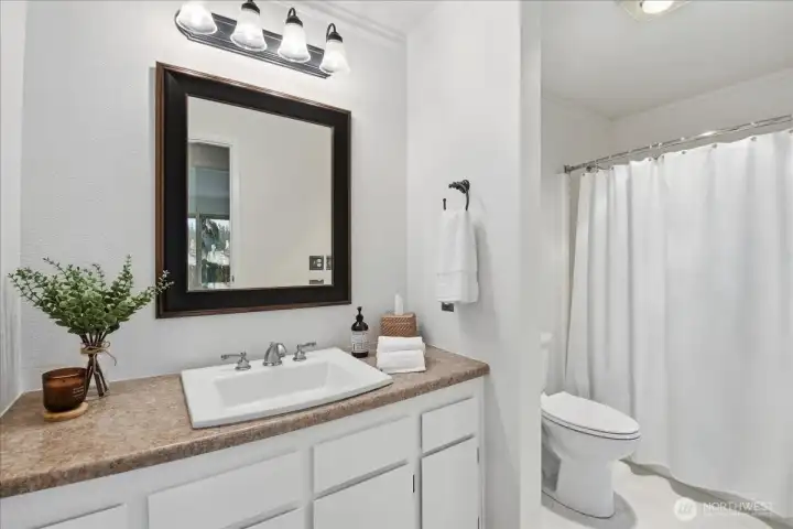 Refreshed bath with new flooring and toilet.