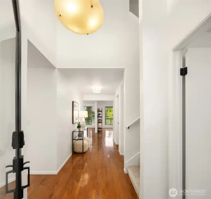 Light filled entry hallway with hardwood floors and soaring ceilings
