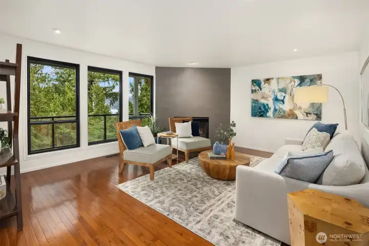 Bright living room with fireplace and expansive windows framing Lake Washington views