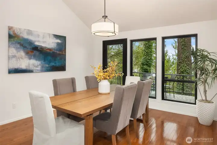 Inviting dining space with expansive windows, warm hardwood floors, and easy access to the deck for indoor-outdoor entertaining