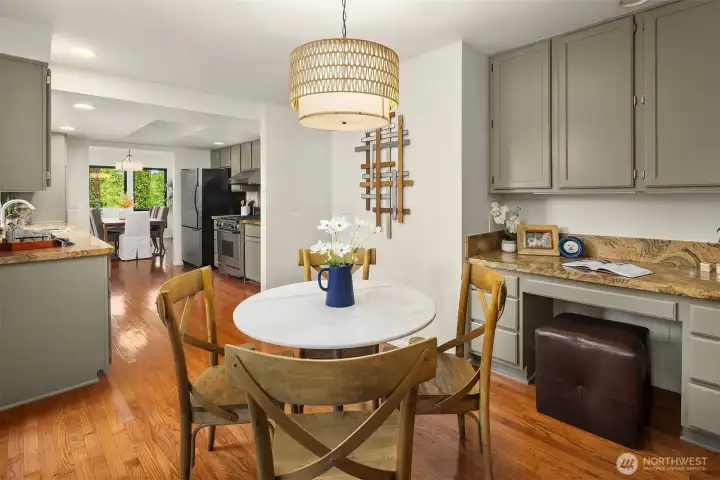 Charming breakfast nook with built-in desk and cabinetry, offering seamless connection to the kitchen and main living spaces