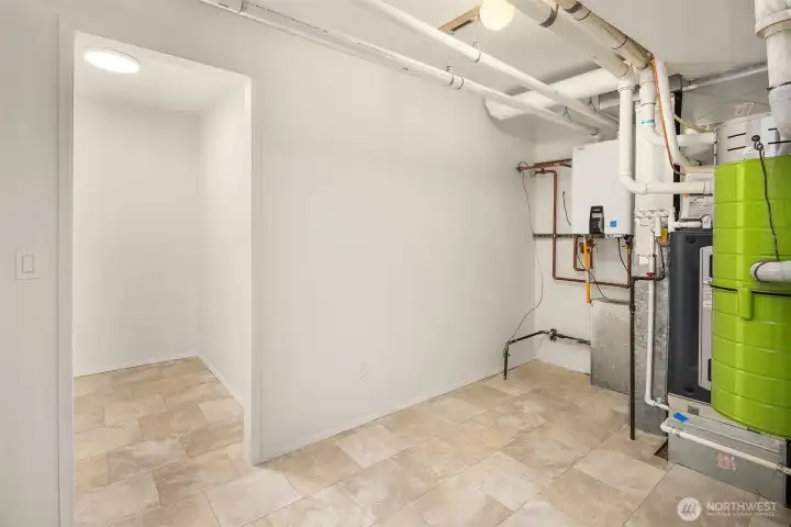 Large mechanical and storage room featuring ample space for organization and a furnace with heat pump system installed in 2024 for modern efficiency