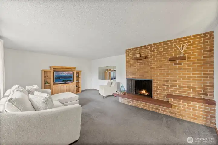 Floor to ceiling brick  fireplace that is wood-burning fireplace, stone hearth, large windows, and fabulous vintage mirrors!