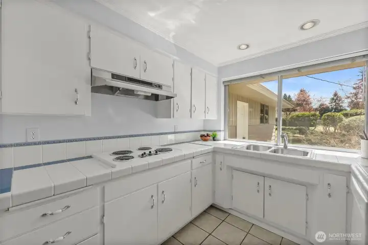 Huge kitchen window, adorable white tile counters and those forever well-made cabinets