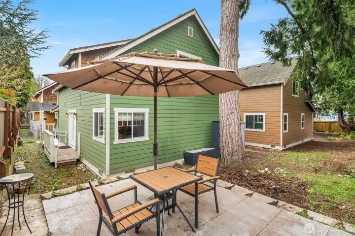 Sun drenched, poured concrete patio, perfect for lazy Sunday lounging, sizziling BBQs, and warm gatherings under open skies.