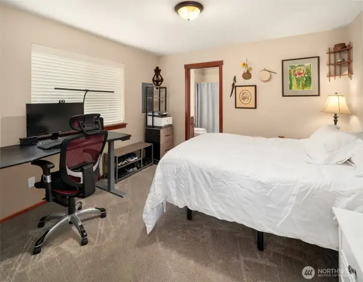 Spacious main floor primary bedroom bathed in natural light from its large window, tons of room in here. ADA accessible shower has a fold down seat, or you can just sing and dance in this really big shower!