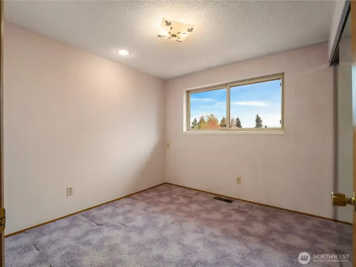 The first bedroom offers additional recessed lights and sweeping views of the mountains.