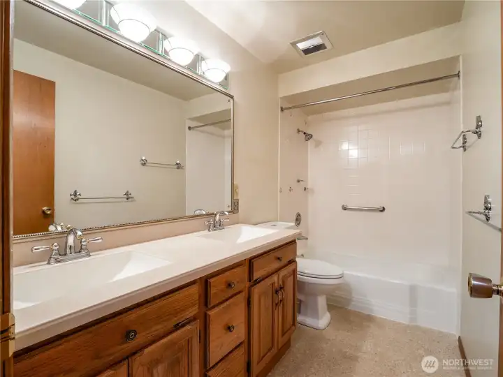 This large, full bathroom serves the upper level of the home. It is light and bright and offers dual vanity sinks and huge mirror.