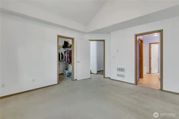 Walk in closet and primary bath as accessed from the primary suite.