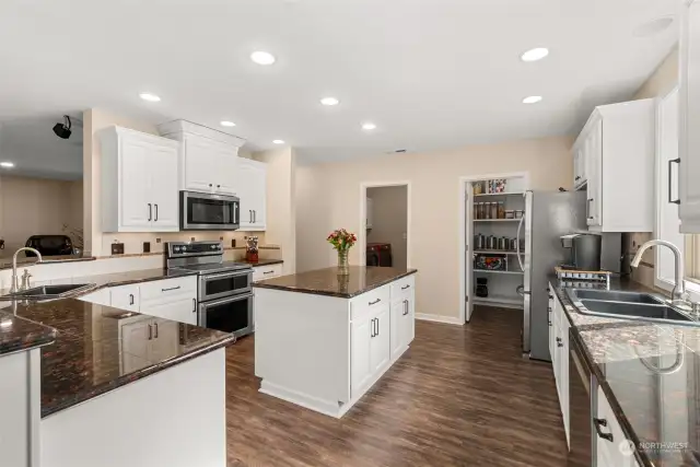 Enjoy modern features throughout the kitchen, staggered white cabinets, granite coutertops, flooring, double sinks, and a stylish kitchen island.