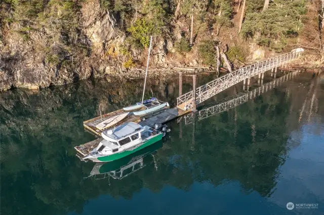 Shared 4-user dock. Each user is allotted 25' with locations rotated annually. The raft on the far side with the cat is only there temporarily.