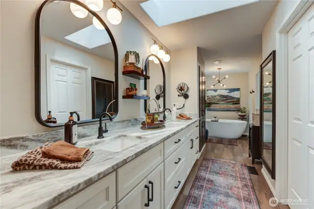 Primary bathroom with quartz counters, new cabinets, skylight & beautiful free-standing tub.