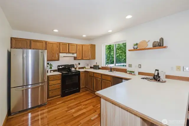 Kitchen overlooking the back deck and mature evergreens