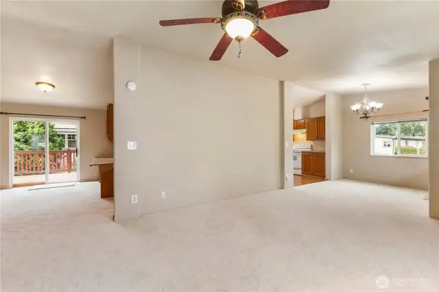 Check out this large great room off front and back of home with earth tone colors all new plush soft carpeting,high ceilings and ceiling fans to stay cool
