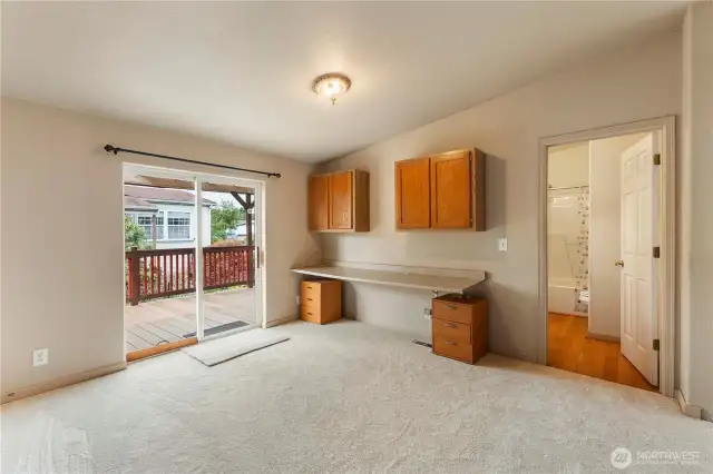Second view of  large office bonus room media room off the side of home with access to covered deck area with built in shelving
