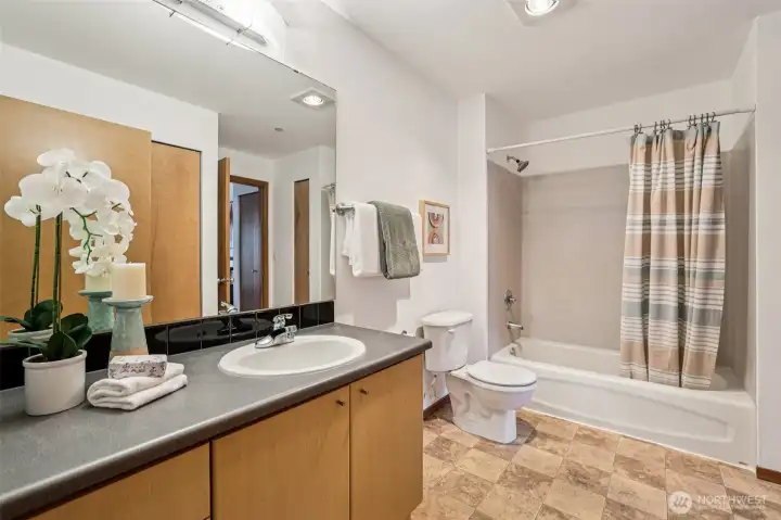 The full bathroom connects to both the bedroom and the living space, for ease of daily life.