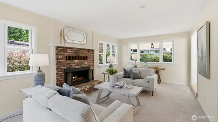 Bright and inviting living room with wood burning fireplace and new carpets throughout the home