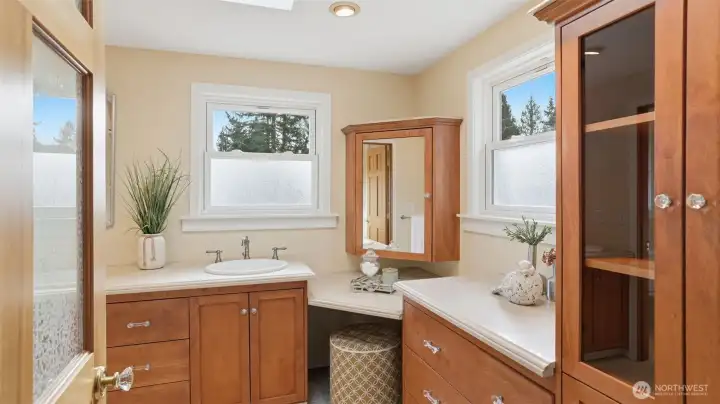 Dual vanities, a dressing table, and abundant storage are just the beginning of this primary bathroom.