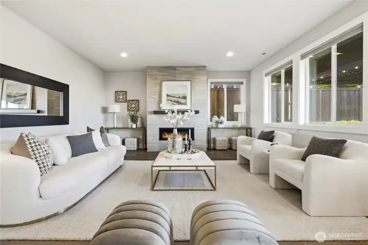 Grand living room anchored by a cozy gas fireplace and expansive windows that fill the space with natural light.